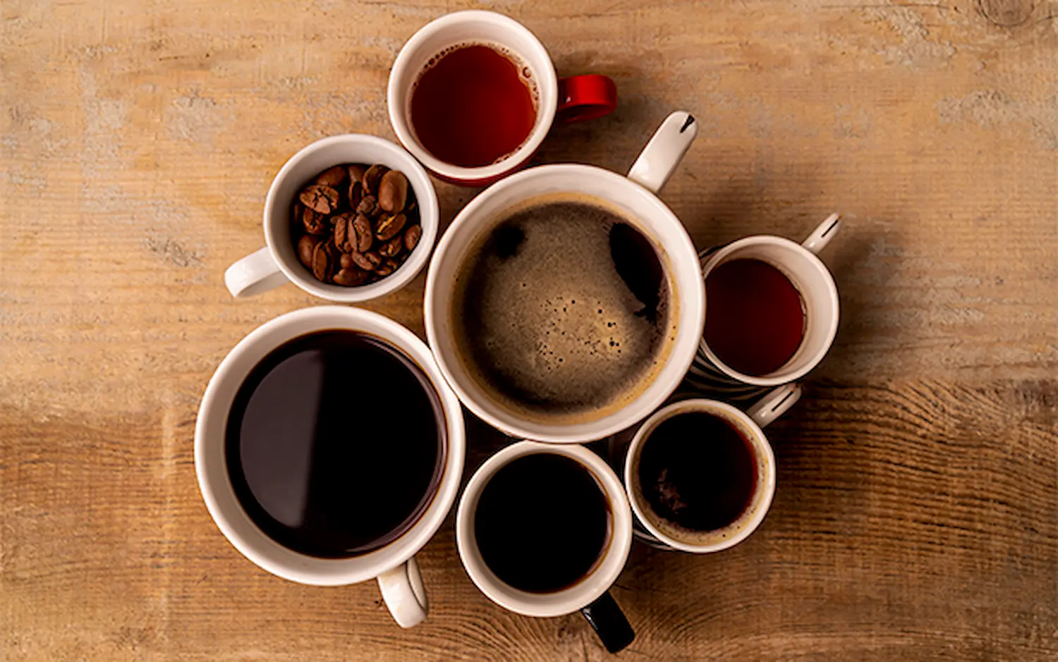 Xícara de café com grãos torrados ao fundo